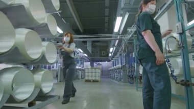 maskeli kadın fiberglas bobin ile kabin depoda iter.