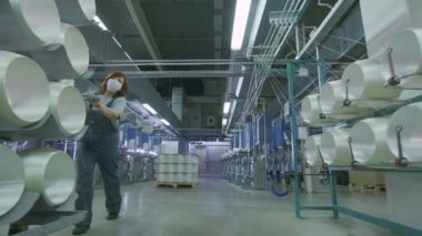 siyah üniformalı kadınlar fiberglas bobin rafları ile çalışır
