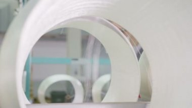 mühendis bardaklarda bobin arkasında cam elyaf iplik kalite kontrol eder.