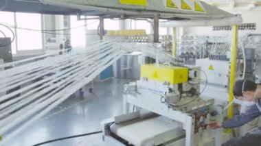 çalışan logo denetimleriyle üniformalı fiberglas parçalar konveyör kesilmiş.