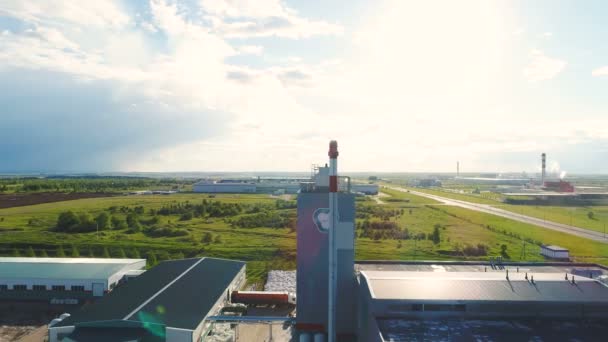 Aerial plant buildings smoke pipe tower with logo among landscape — Stock Footage Aerial plant buildings smoke pipe tower with logo among landscape Stock Video