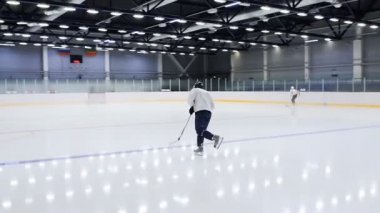 Genç hokey oyuncusu sopayla Ice arena skates