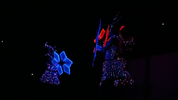 暗闇の中でダンスと led の花の明るいネオンの女の子のドレスします。 — ストック動画