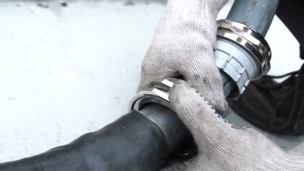 Closeup worker in gloves turns lever to connect rubber pipe — Stock Video