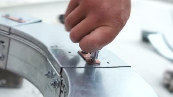 Closeup employee twists fast screw into large metal circle — Stock Video