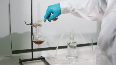 arka görünümü asistan kahverengi sıvı şişesi dökülen.