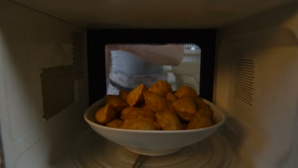Vista desde el horno microondas mujer abre la puerta y saca el plato — Vídeo de stock