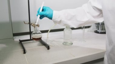 bilim adamı rafine şeker parça sınav için kahverengi sıvı içine koyar