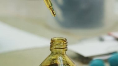 closeup asistan pipet ile ham petrol örnek alır