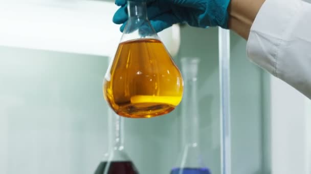 Olieproducten van verschillende kleuren en hand toont gele vloeistof — Stockvideo
