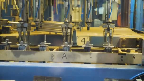 Automatiserad maskin sätter metallplattan stackar på transportband av arm — Stockvideo