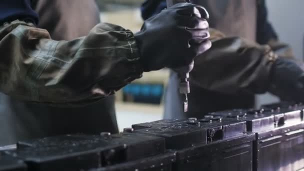 Trabalhadores em desgaste protetor giram torções em novas baterias — Vídeo de Stock