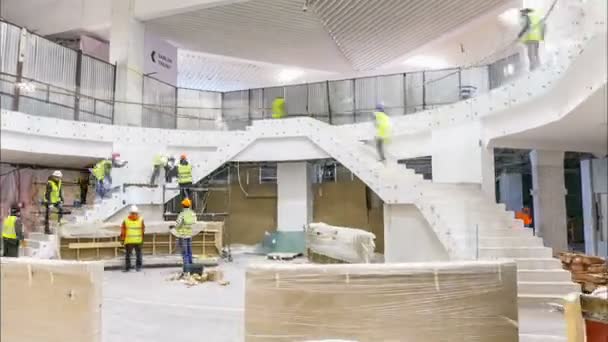 Квалифицированные рабочие устанавливают поручни на лестнице торгового центра — стоковое видео