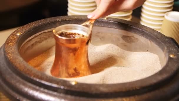 Closeup barista prepares traditional coffee in hot sand — Stock Video