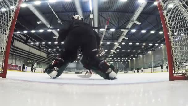 zkušený brankář v černém brání cíle na hokejový zápas