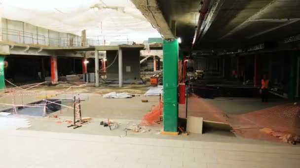 Рабочая группа кладет керамическую плитку с мокрым цементом в торговом зале — стоковое видео