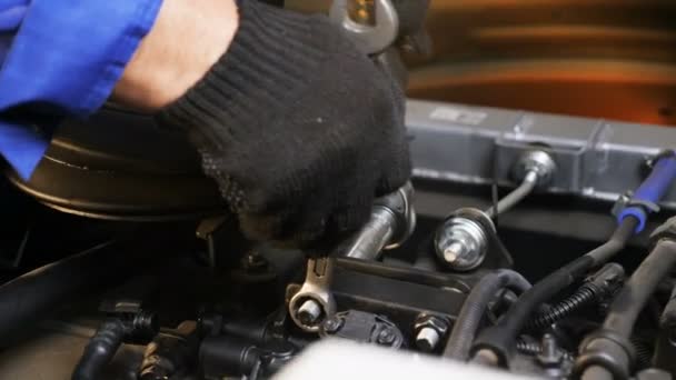 Skilled worker fixes screws with wrench on motor closeup — Stock Video