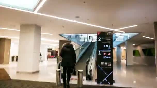 Timelapse женщина идет к эскалатору в торговый центр более высокого уровня — стоковое видео