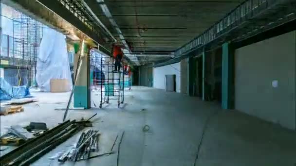 Beweging langs winkelcentrum constructie met werknemers werkzaam — Stockvideo