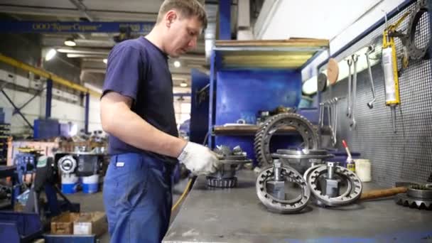 Side view technician checks and assembles truck part — Stock Video