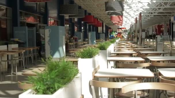 Mulheres andam ao longo de mesas de praça de comida vazias entre cafés — Vídeo de Stock