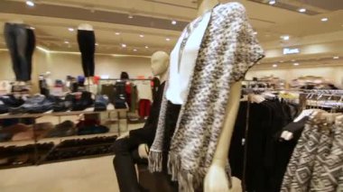 stand ile giysi rafları ve mankenler etrafında hareket