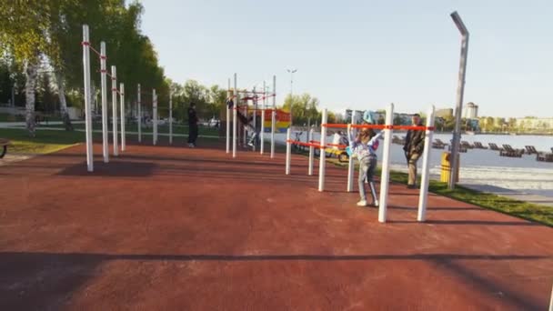 Atletische jongens trainen op sportveld met horizontale balken — Stockvideo