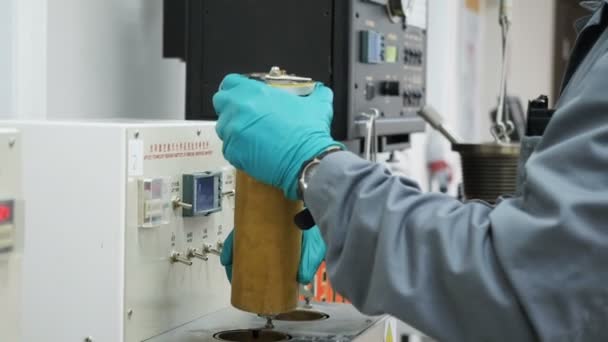 Zijaanzicht lab assistent zet cilinder in onderzoeken apparaat — Stockvideo
