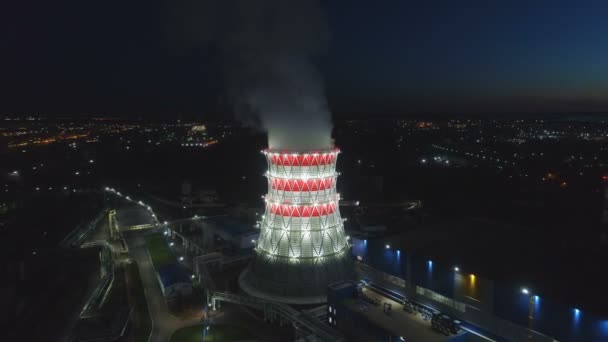 Vista de pájaro torre de enfriamiento en la luz del proyector y ciudad oscura — Vídeo de stock