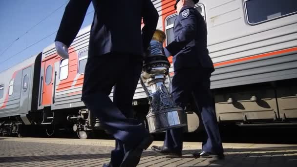 Rallentatore persone in uniforme camminare con enorme tazza lungo treno — Video Stock