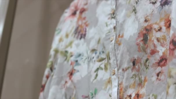 Close view blusa feminina com padrões florais no cabide — Vídeo de Stock