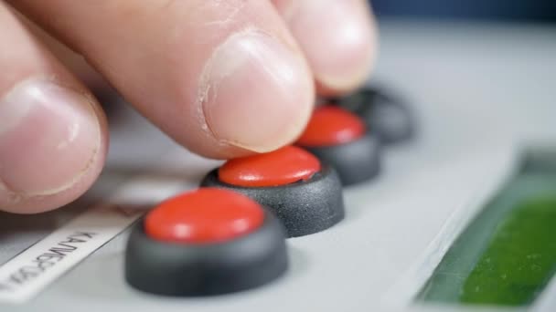 Closeup vingers druk op rode en zwarte knoppen op het bedieningspaneel — Stockvideo