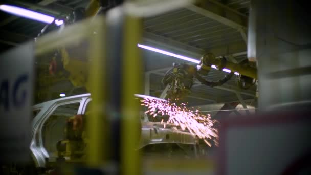 Zobrazit zpoza oplocení robota zbraní svaru auto kovové tělo — Stock video