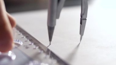 görünümü Kapat yetenekli tasarımcı mükemmel daire metal pusula ile proje kroki beyaz kağıt üzerine çizer