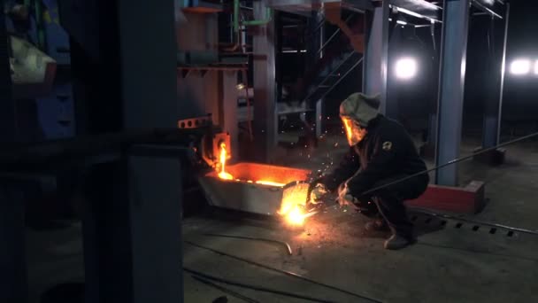 Trabajadores con máscaras protectoras operan con metal fundido — Vídeos de Stock