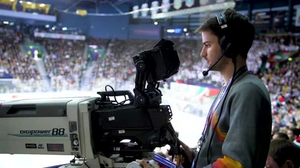 Sidovy kamera man arbetar på hockey spel på åskådare platser — Stockvideo