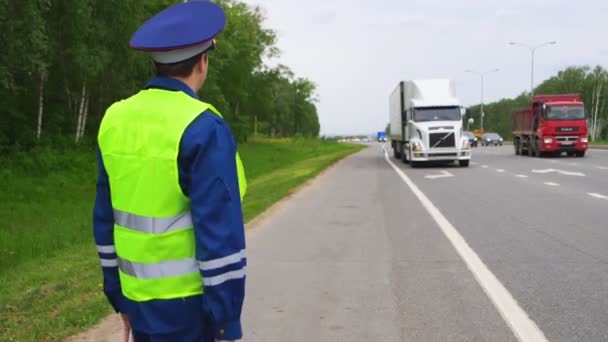 Trafik müfettişi karayolu üzerinde beyaz kamyon stop işaretini gösterir — Stok video