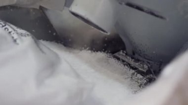 küçük beyaz topları büyük çanta closeup makineye dökülür