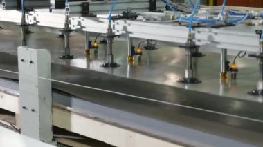 atölyede manipülatör tarafından taşınan parlayan metal levha