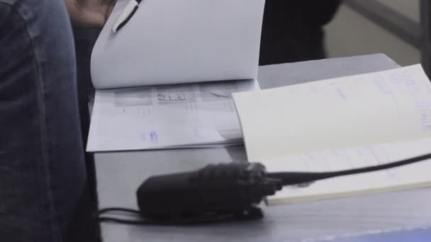 Режиссер за столом со сценарием и радио во время съемок крупным планом — стоковое видео