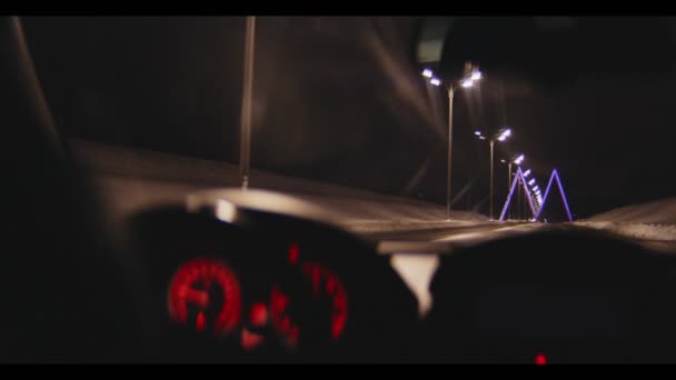 Car drives along winter road to large sign M at night — Stock Video