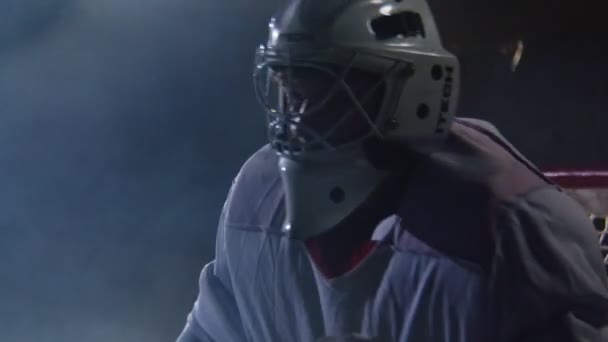Вратарь хоккея в защитной маске у ворот на темном катке — стоковое видео