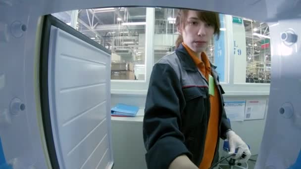 Работник проверяет холодильник с цифровым видом на метр изнутри — стоковое видео