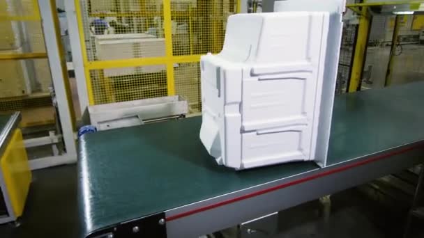 Работник забирает и уносит на заводе ящики для холодильника — стоковое видео