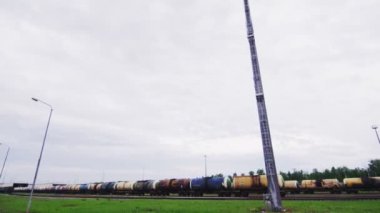 bulutlu gökyüzü altında demiryolu üzerinde petrol ürünü sarnıçlar ile tren