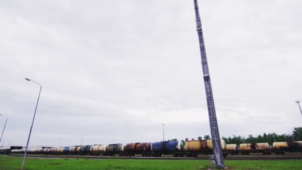 Tren con cisternas de productos petrolíferos en ferrocarril bajo cielo nublado — Vídeos de Stock