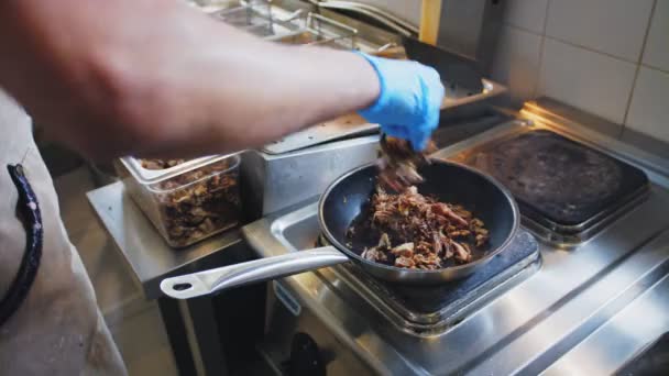 Hombre joven fríe la carne con llama brillante en café de comida de la calle — Vídeos de Stock