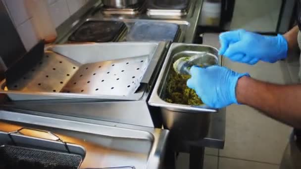 Шеф-повар готовит еду во фритюрнице с горячим маслом в ресторане крупным планом — стоковое видео