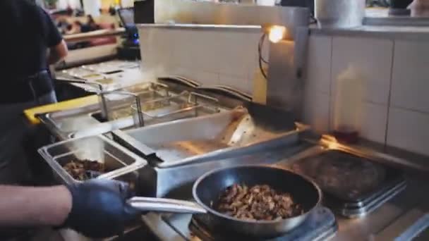 Chef frietjes vlees met olie en brandende vuur in Fast food café — Stockvideo