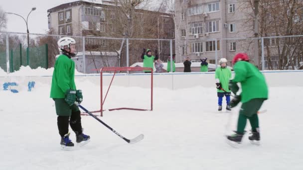 年轻的冰球运动员在冬季在露天溜冰场上训练 — 图库视频影像